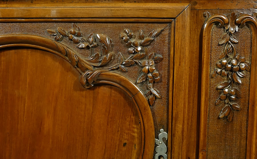 Sculpture de volutes, chutes florales, feuilles nervur&eacute;es sur buffet galb&eacute; en noyer massif de Provence